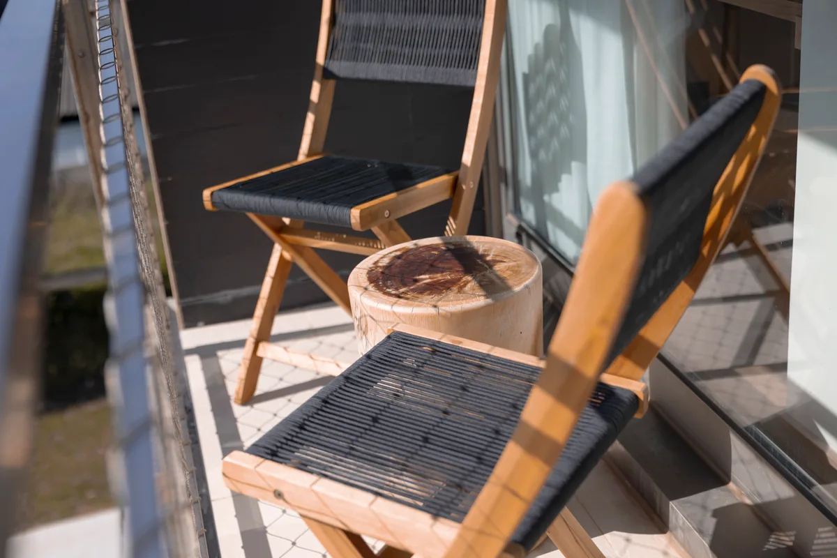 Dos sillas de madera y cuerda en la terraza de una habitación de Malates