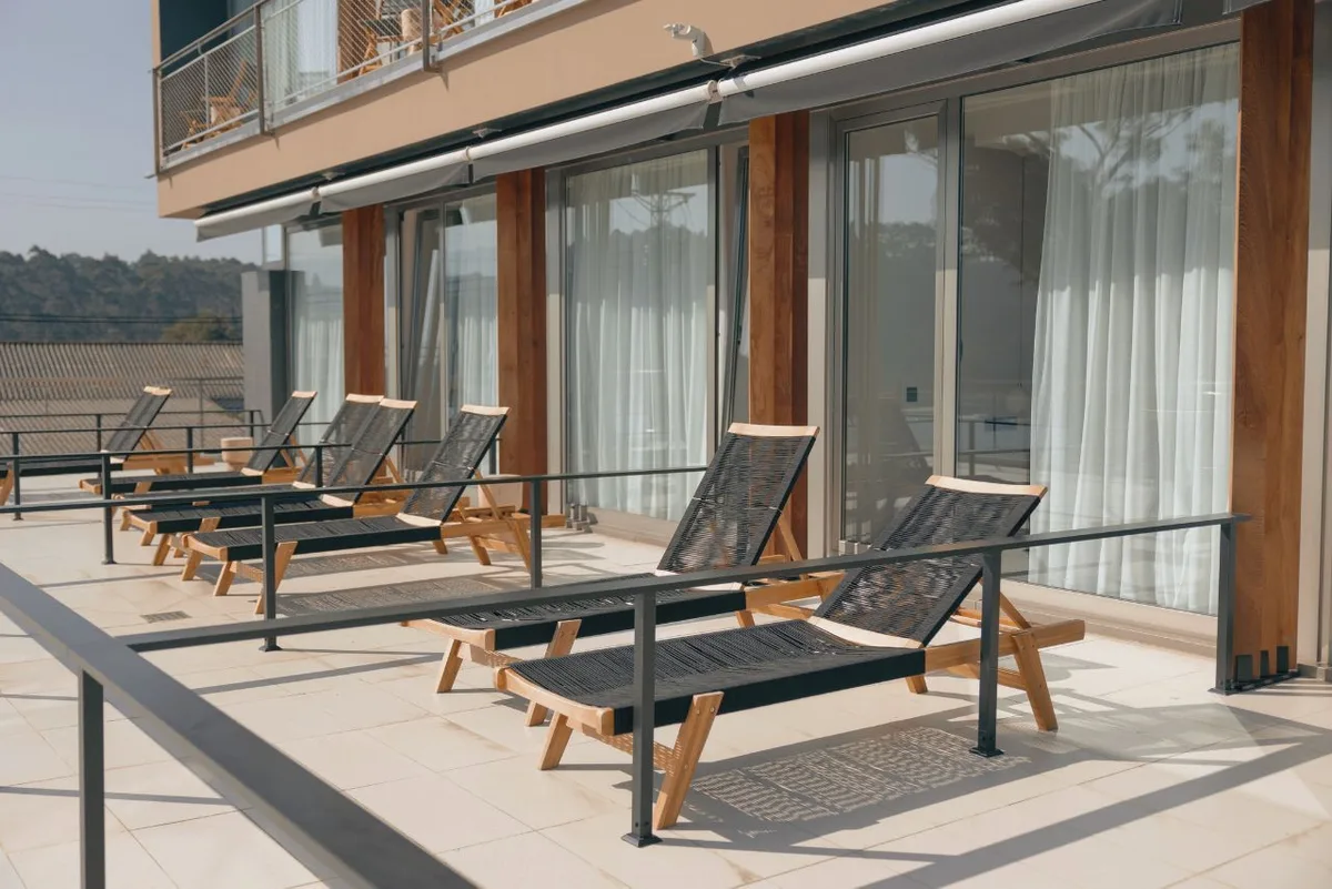Tumbonas de madera al sol en la terraza del hotel en Foz Malates